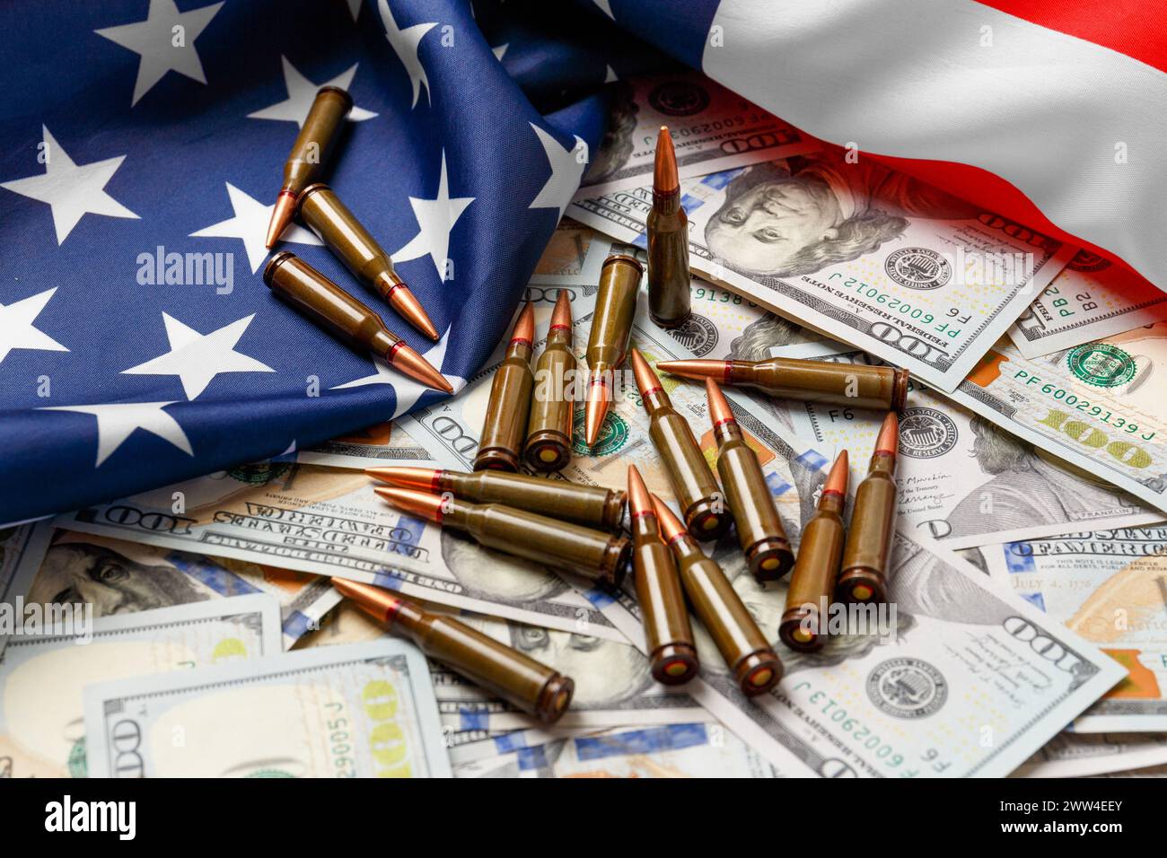 Amerikanische Flagge, Dollar, Kugeln, Patronen, Munition. Das Konzept des Leihpachtvertrags, der Armee, des Waffenverkaufs. Militärindustrie, Krieg, Weltwaffen Stockfoto