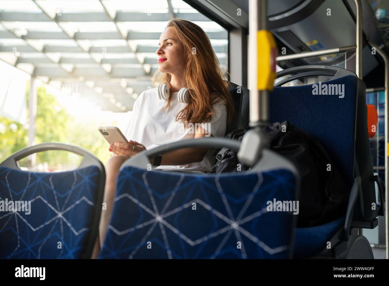 Hübsche Frau fährt mit dem Bus durch die Stadt. Öffentliche Verkehrsmittel in der Stadt. Stockfoto