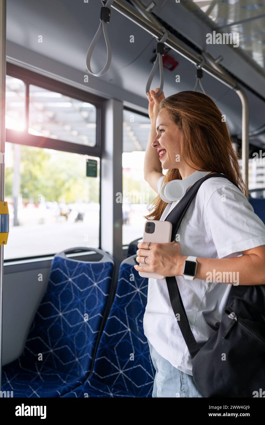 Eine junge Studentin fährt mit dem Bus durch die Stadt. Personen- und öffentliche Verkehrsmittel. Stockfoto
