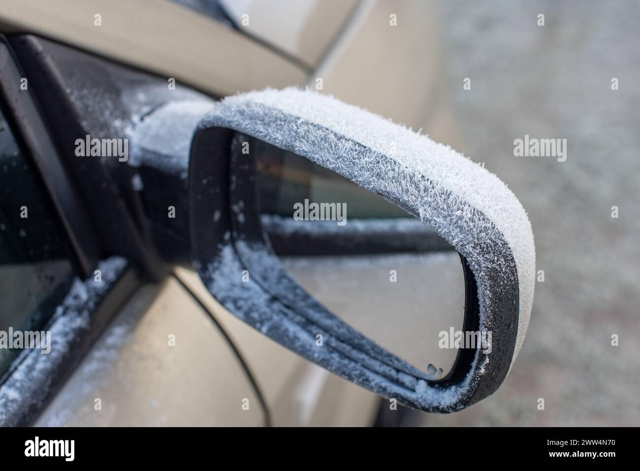 Frost bildet sich auf einem Autospiegel. Gefrorener Seitenspiegel eines Autos im Winter Stockfoto