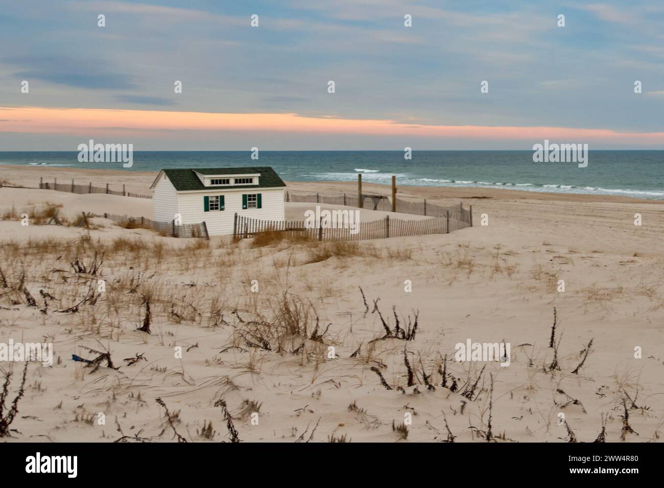 Eine einsame Hütte sticht an einem ruhigen Strand hervor Stockfoto