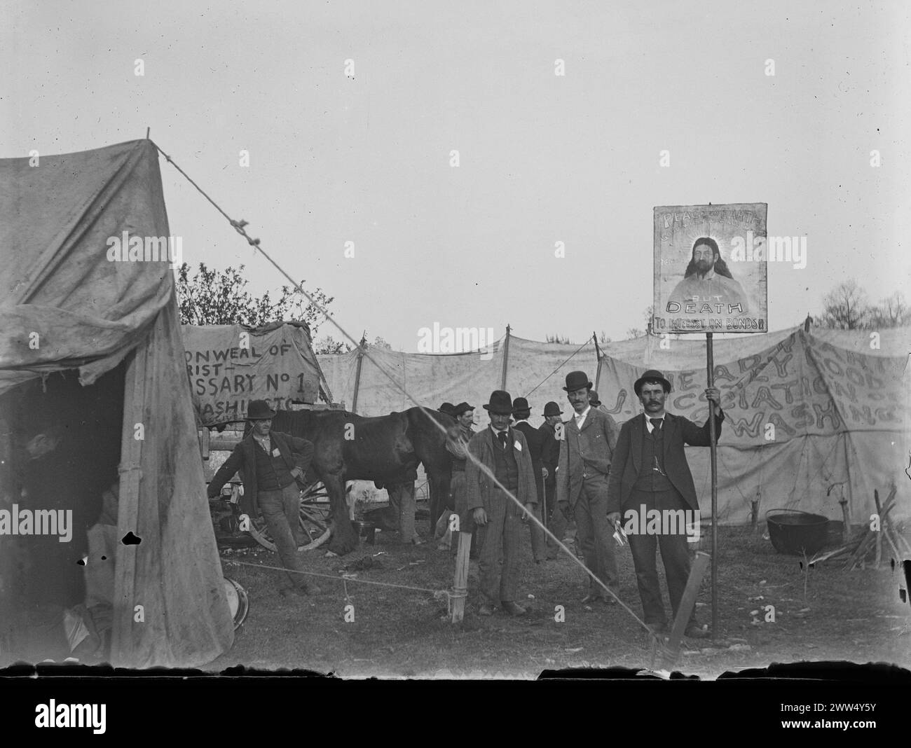 Coxeys Armee-Protest, 1894. Lager, als sie nach Washington, D.C. marschieren. Männer und ein Pferd stehen um den Zeltbereich von Coxeys Armee herum, Banner sind im Hintergrund und ein Mann hält ein Schild: Coxeys Armee war ein protestmarsch arbeitsloser Arbeiter aus den Vereinigten Staaten, angeführt von dem Ohio-Geschäftsmann Jacob Coxey. Foto: Ervin S. Hubbard Stockfoto