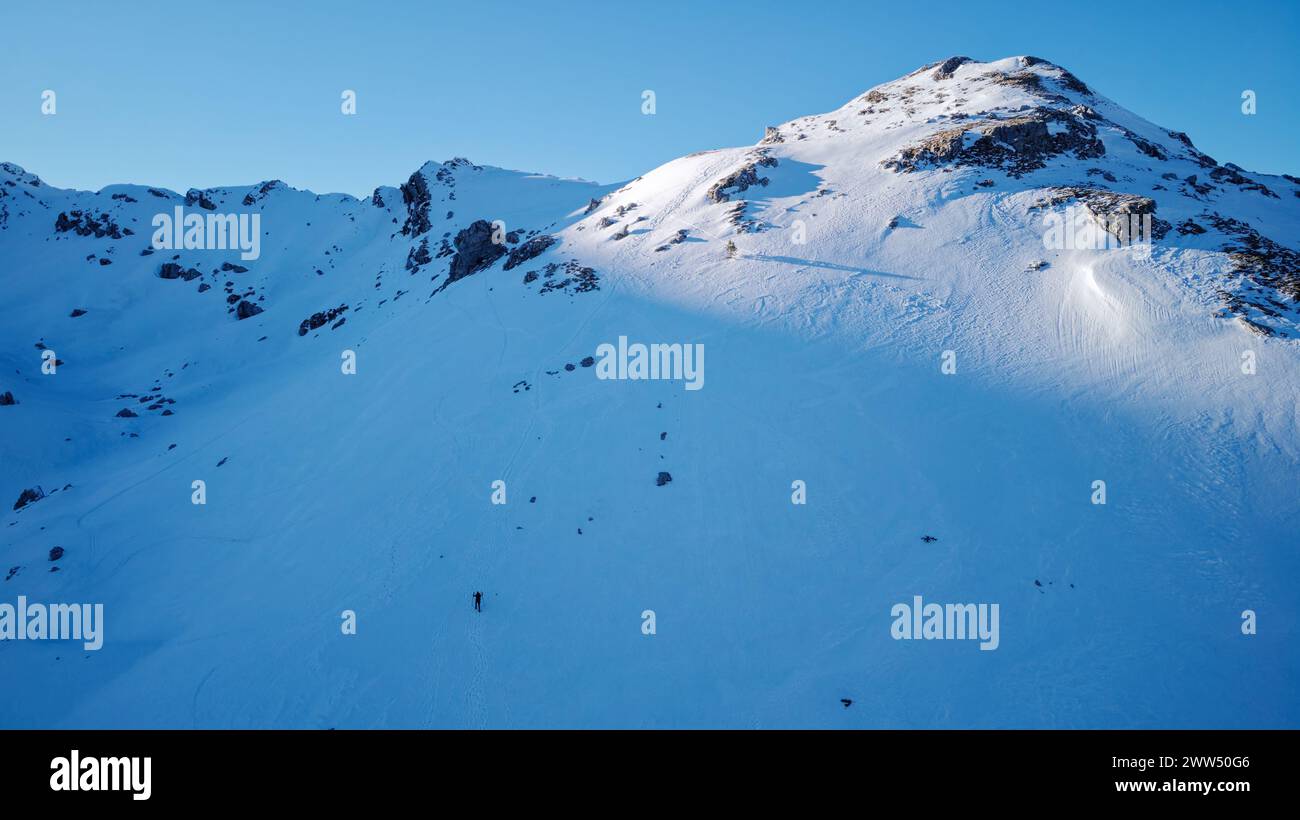 Alleinbergsteiger wandern an einem sonnigen Wintertag zum Gipfel. Reisen und sich mit der Natur verbinden. Stockfoto