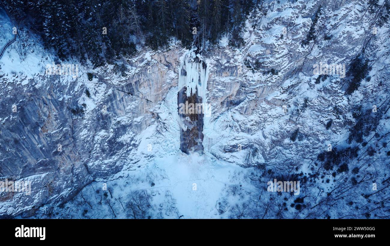 Drohnenansicht eines teilweise gefrorenen Wasserfalls aus der Luft. Wunderschöne und zauberhafte Winterurlaubslandschaft für Naturliebhaber. Skakavac Wasserfall in Sarajevo. Stockfoto