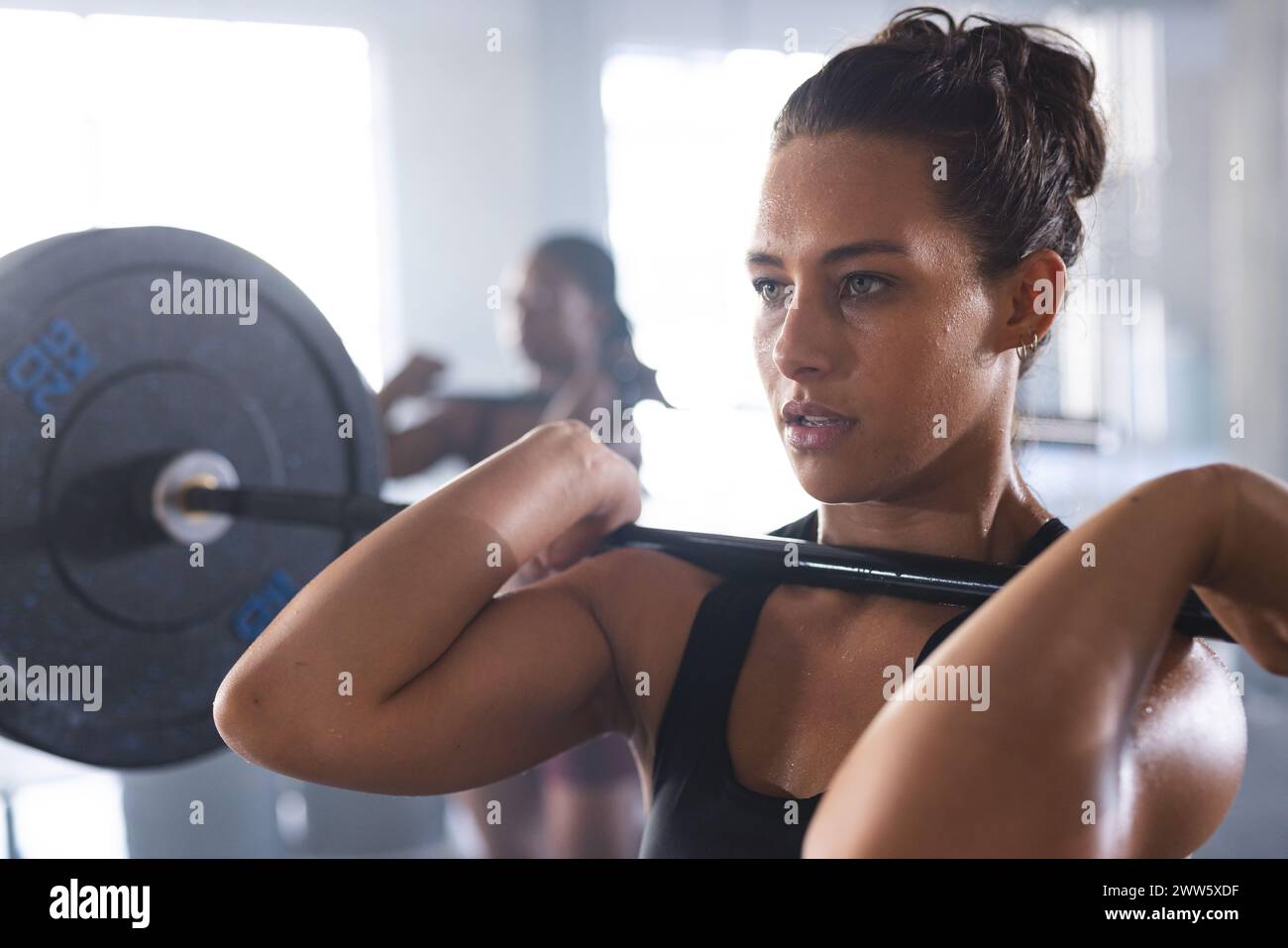 Eine kräftige, kaukasische Frau hebt im Fitnessstudio eine Langhantel Stockfoto