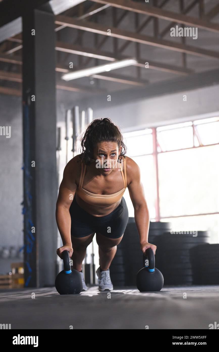 Eine starke und fitte Frau aus Kaukasier nimmt im Fitnessstudio an einem Kettlebell-Workout Teil Stockfoto
