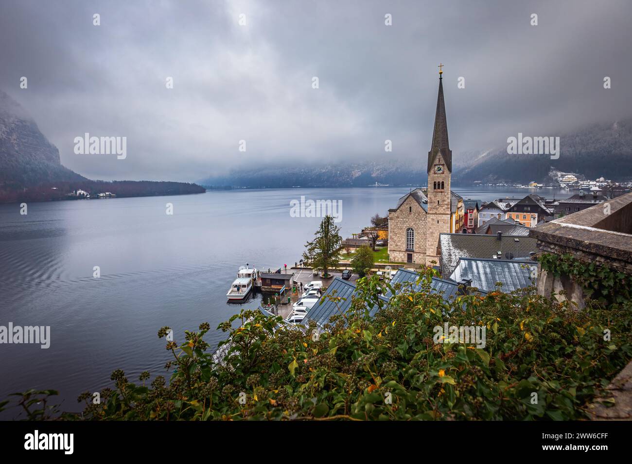 Hallstatt, Österreich - der weltberühmte Hallstatt, die zum UNESCO-Weltkulturerbe gehörende Stadt am See mit der Lutherischen Kirche Hallstatt an einem kalten nebligen Tag mit Schneefall Stockfoto