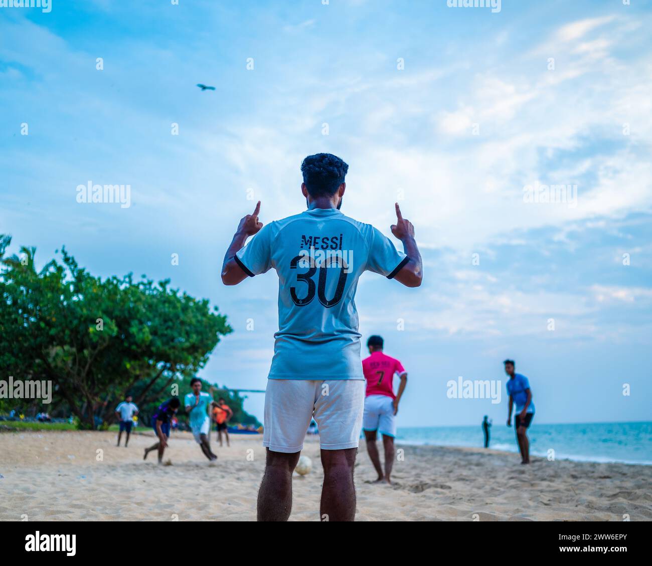 Junge spielt Fußball am wunderschönen Strand, genießt Outdoor-Sport, bleibt aktiv für gute Gesundheit, schöner Strand von Kerala, Teamwork, Sport. Stockfoto