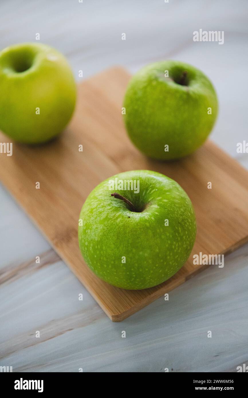 Grüne Äpfel auf Schneidebrett Stockfoto