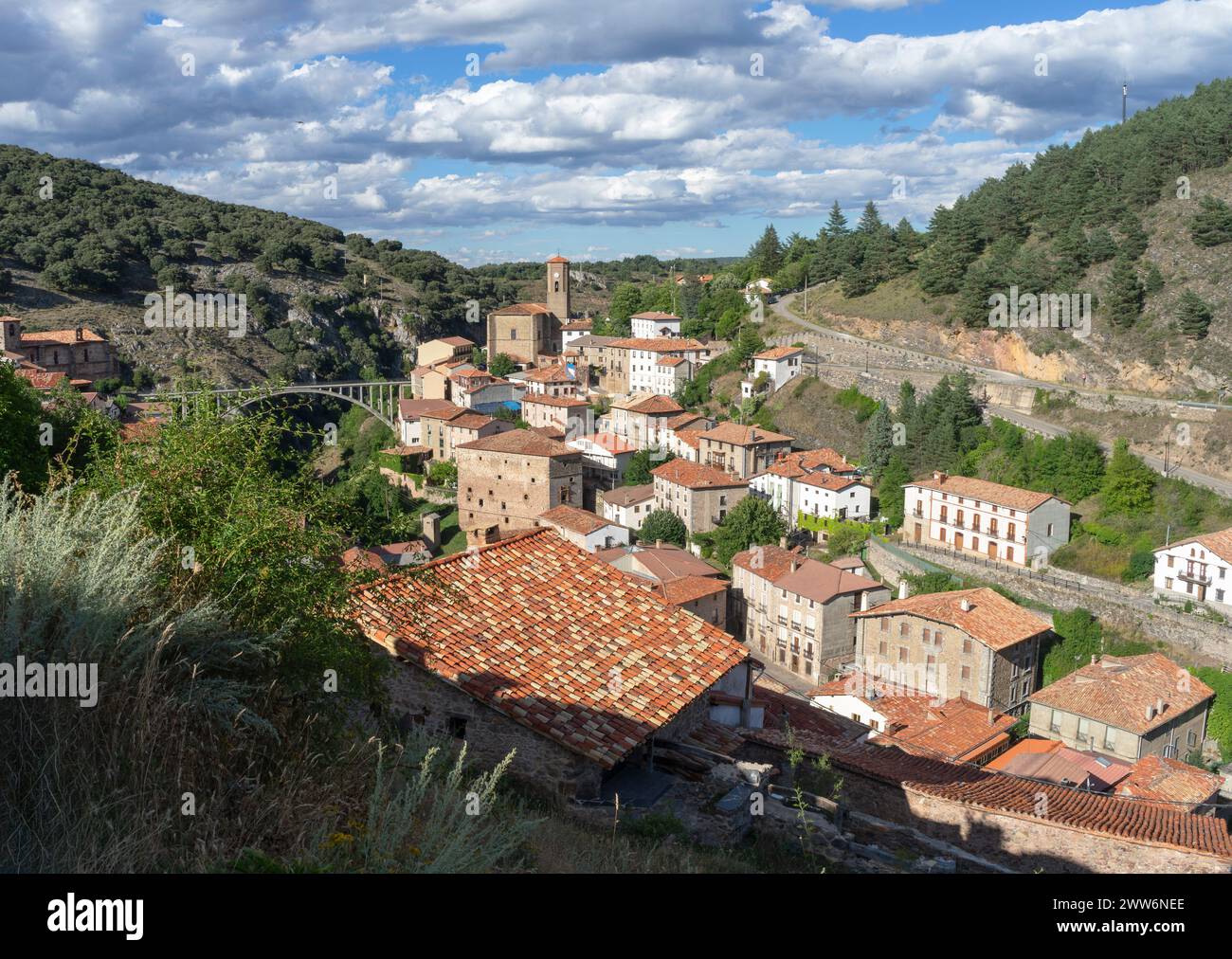 Ein kleines Dorf mit vielen Häusern und einer Kirche. Die Häuser sind meist rot und die Kirche hoch. Ortigosa de cameros. La rioja. Spanien. Stockfoto