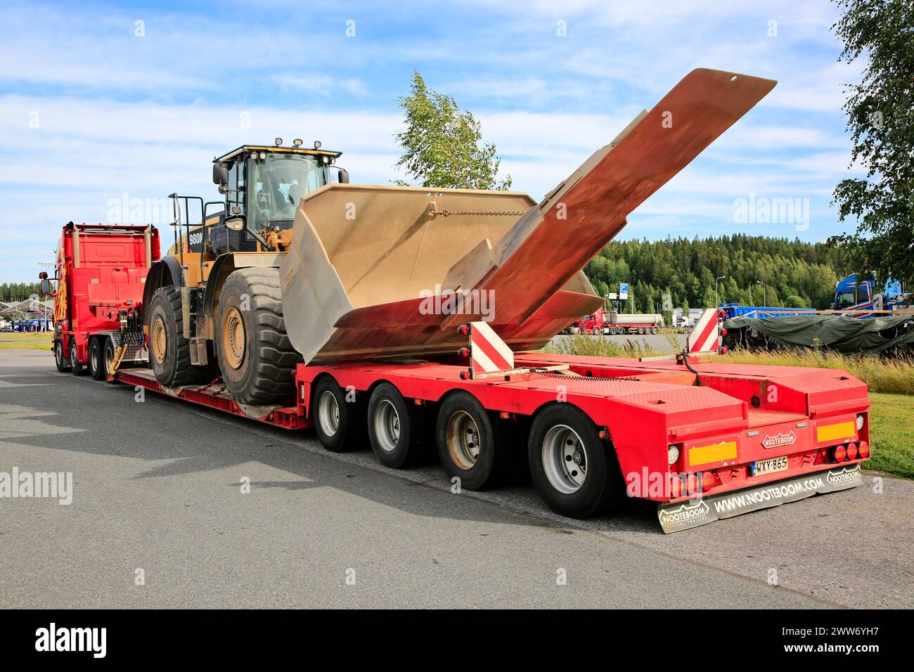 Scania Truck PHP Group und Cat 980K Radlader mit Schaufel und Anbaugerät am Nooteboom Tieflader-Anhänger, Rückansicht. Forssa, Finnland. August 2022. Stockfoto
