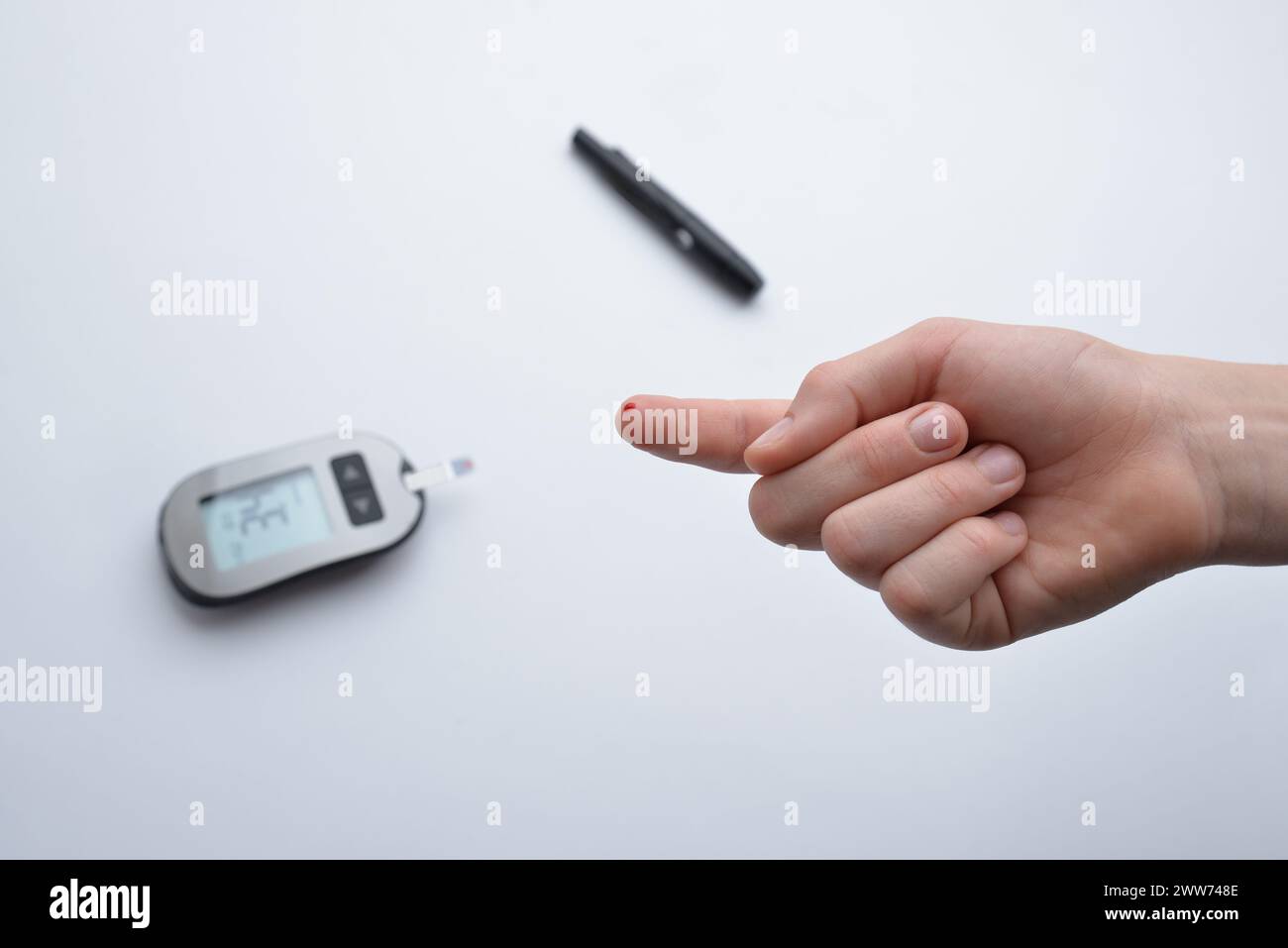 Niedriger Blutzuckerspiegel nach Testung mit Streifengerät und kleiner Blutprobe festgestellt. Gesundheitsmonitoring und Diabetesmanagement veranschaulichen Stockfoto