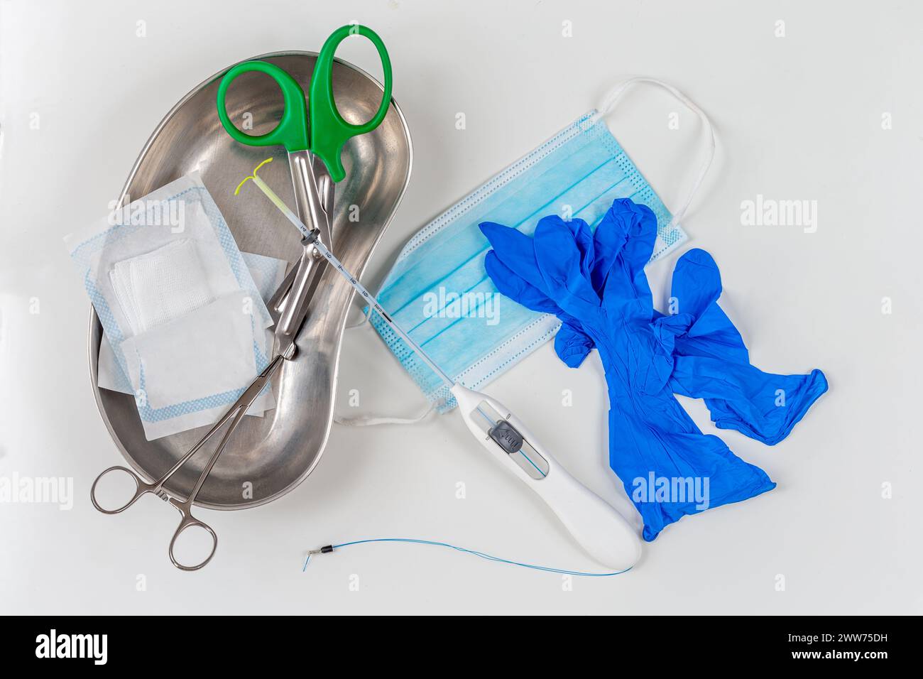 IUD mit medizinischen Geräten auf einer grauen Arbeitsplatte, Ansicht von oben vor dem Eingriff. Stockfoto