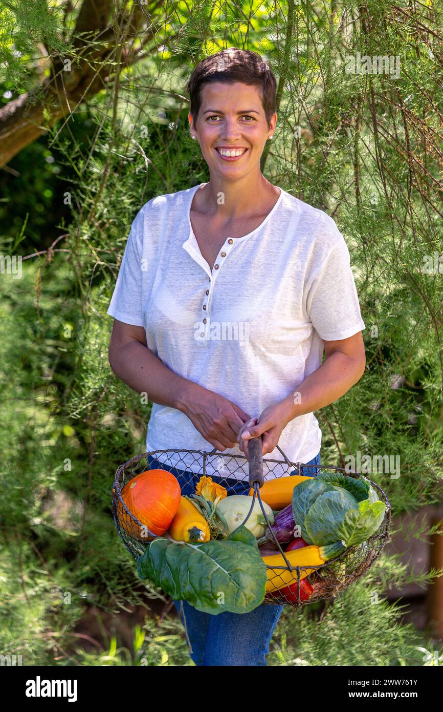 Halblanges Porträt einer Frau mit der Ernte aus dem Gemüsegarten. Stockfoto