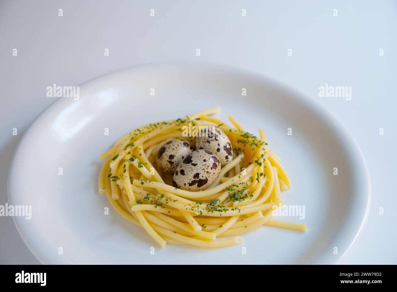 Drei Wachteleier in einem Nest aus Spaghetti. Stockfoto