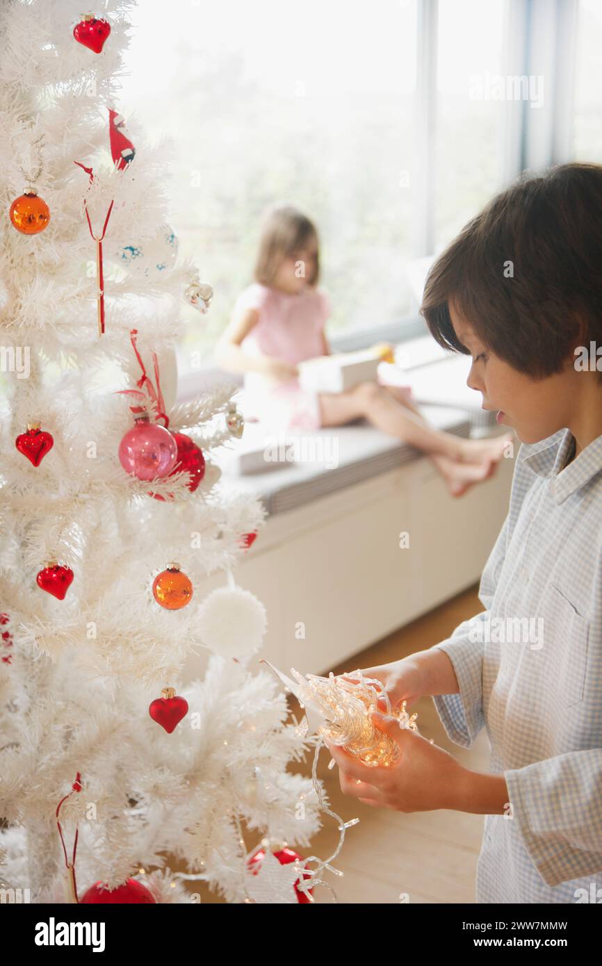 Kleiner Junge dekorieren Weihnachtsbaum Stockfoto