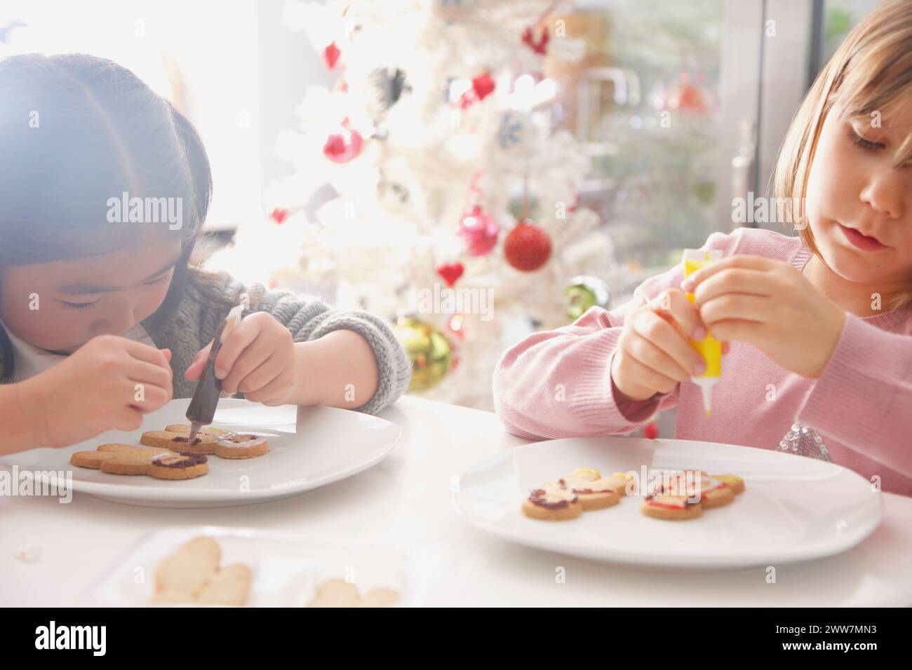 Zwei junge Mädchen schmücken Gingerbread man Kekse Stockfoto