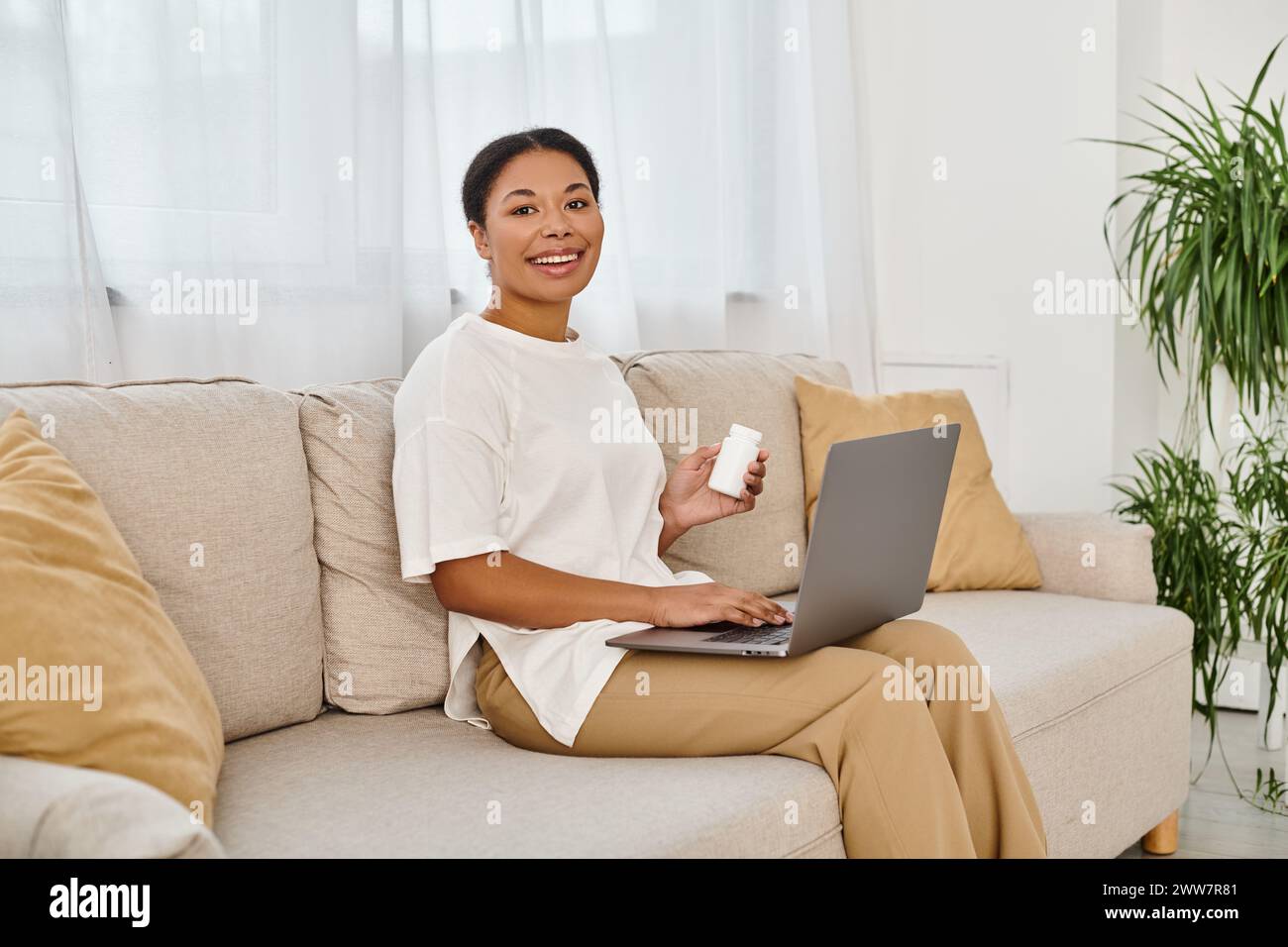 Glücklicher afroamerikanischer Ernährungsberater mit Nahrungsergänzungsmitteln, die online über Laptop Ernährungsberatung geben Stockfoto