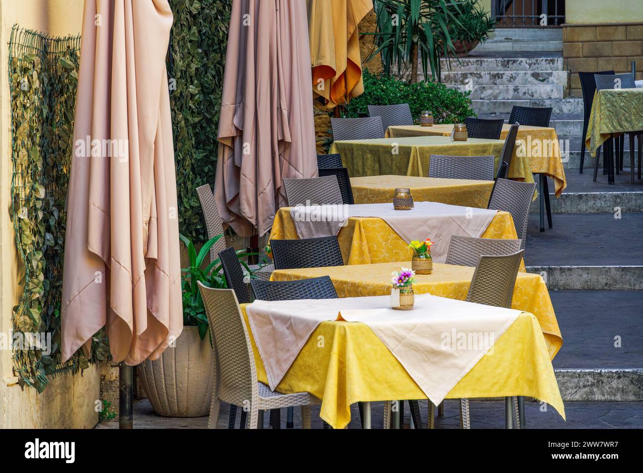 Sitzbereich im Restaurant im Freien mit leeren Stühlen und Tischen in Agrigento, Italien. Stockfoto