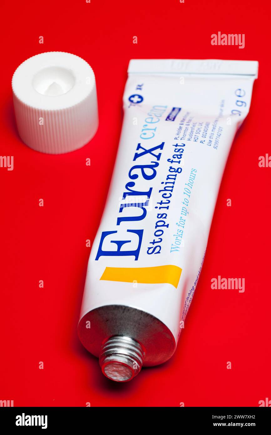 Tube mit geöffneter Eurax-Creme auf rotem Hintergrund Stockfoto
