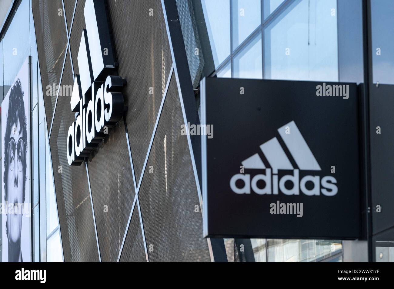 Adidas-Logo und Schriftzug an Modern Store-Fassade 21.03.24, Frankfurt: Symbolfoto, Illustrationsbild, Symbolbild, Illustrationsfoto Adidas-Logo und Schriftzug an Modern Store-Fassade das markante Logo und der Schriftzug von Adidas sind prominent an der modernen Fassade eines Adidas-Stores angebracht, wobei der Laden selbst nur teilweise sichtbar ist, und vermittelt Dynamik und Sportlichkeit in einem urbanen Umfeld. Frankfurt Hessen Deutschland *** Adidas Logo und Schriftzug auf moderner Ladenfassade 21 03 24, Frankfurt Symbolfoto, Illustrationsfoto, Symbolfoto Adidas Logo Stockfoto