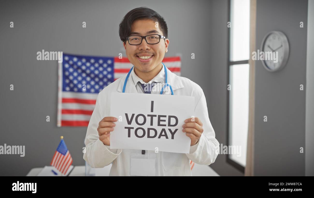 Asiatischer Mann im Laborkittel mit dem Schild "ich habe heute gestimmt" und dem Hintergrund der Flagge bei der Wahl. Stockfoto