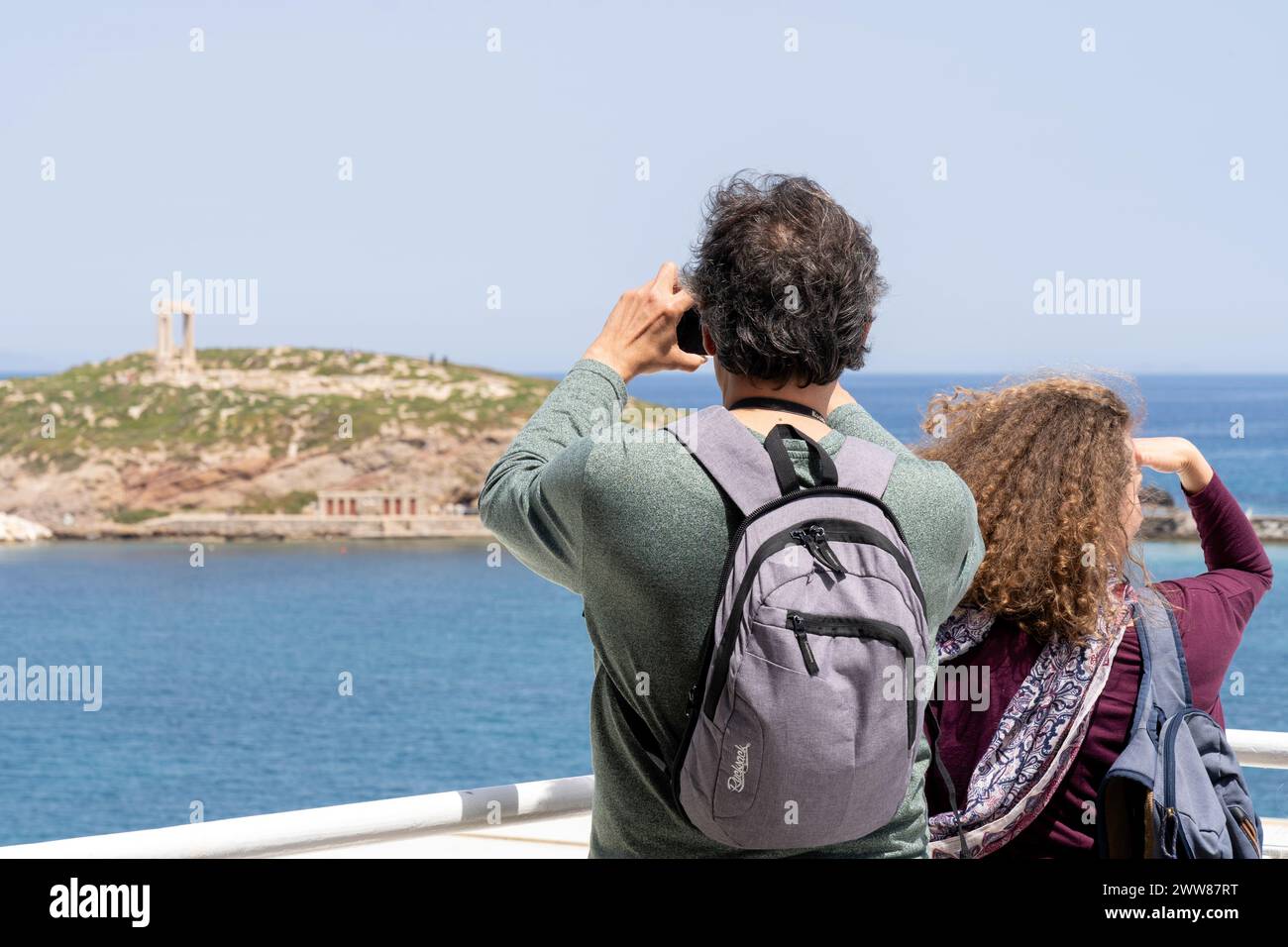 Zwei Touristen an Bord einer Fähre beobachten die Küste der Insel Naxos. Stockfoto