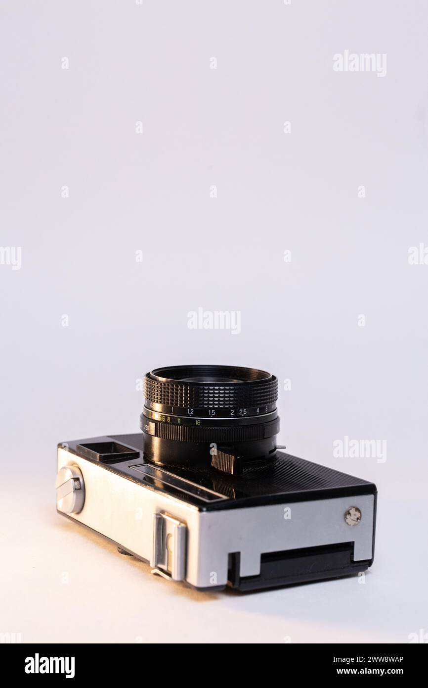 Vintage-Filmkamera mit einem schlanken silbernen Gehäuse und einem klassischen schwarzen Objektiv mit manuellem Fokus, elegant vor einem sauberen weißen Hintergrund. Stockfoto