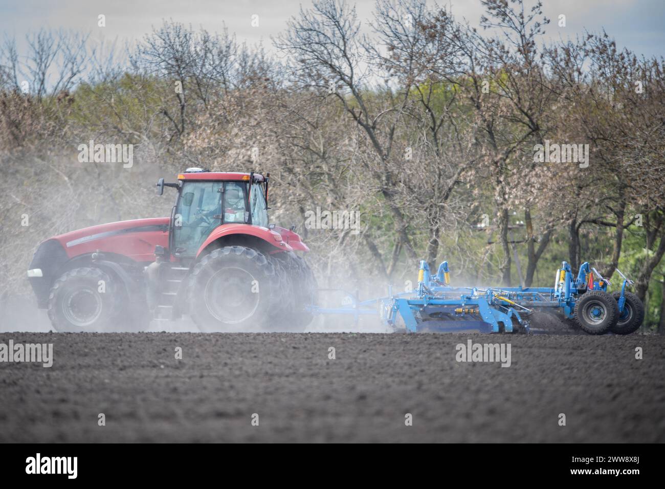 Die Leinwand der Erde: Traktor, der die Landschaft kultiviert Stockfoto