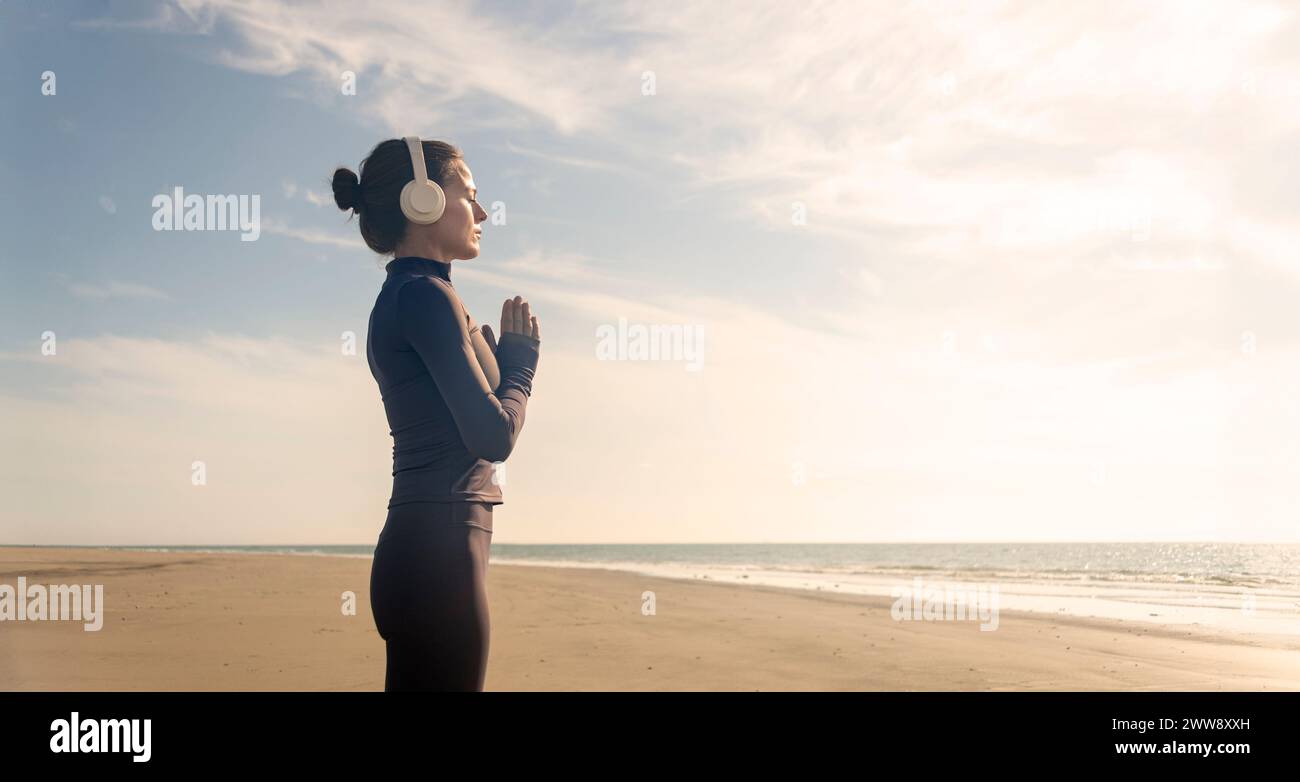 Frau übt Yoga und meditiert am Strand. Sport, aktives Leben. Stockfoto