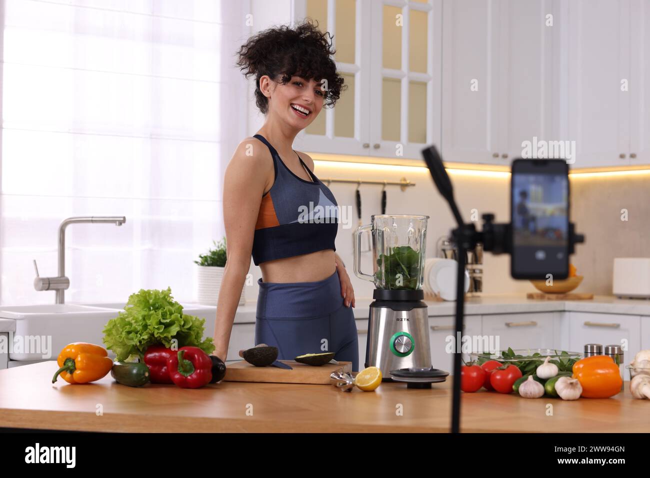 Lächelnder Food-Blogger, der in der Küche ein Video aufnimmt Stockfoto