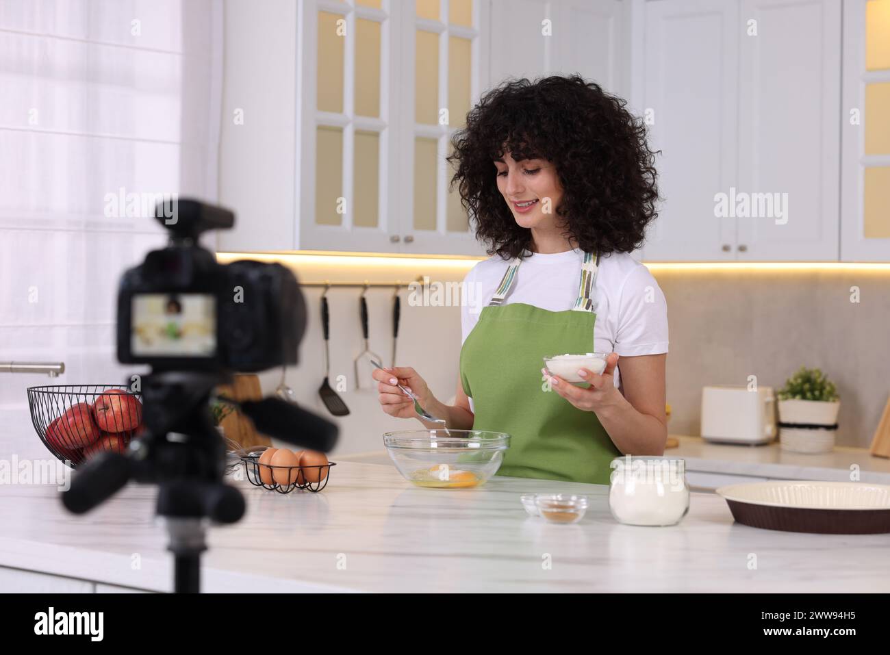 Lächelnder Food-Blogger kocht während der Videoaufnahme in der Küche Stockfoto