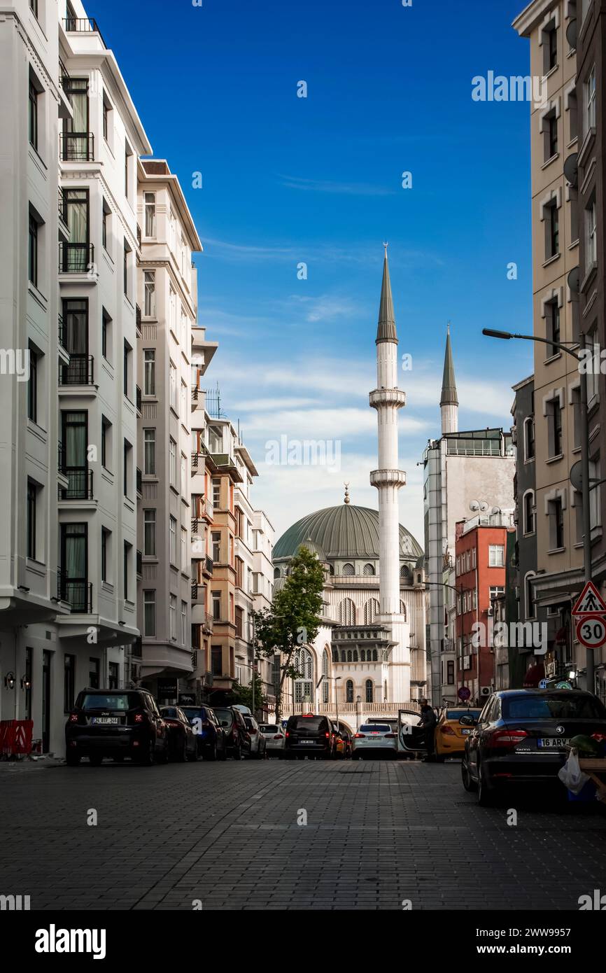 Die neue Moschee auf dem Taksim-Platz in Istanbul wurde von einer Seitenstraße voller Geschäfte und Autos fotografiert Stockfoto