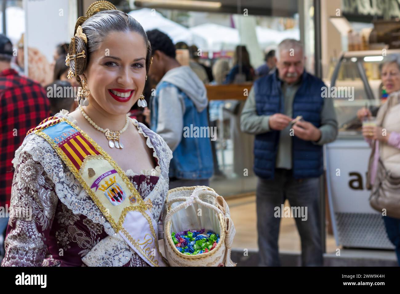 Das Fallas Festival in Gandia Spanien zeigt lebendige Kultur. Frau in traditioneller Kleidung mit einem Blumenkorb verkörpert den festlichen Geist. Stockfoto