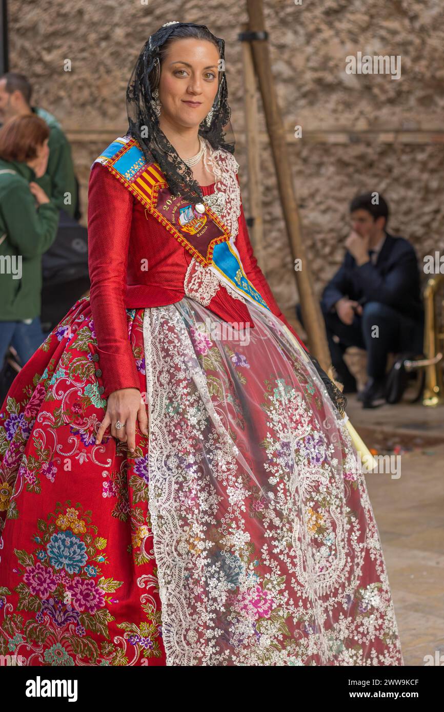 Die traditionelle Eleganz einer valencianischen Fallera. Ihr Kleid, eine lebendige Leinwand der Geschichte, feiert Gandias festliches Erbe. Stockfoto