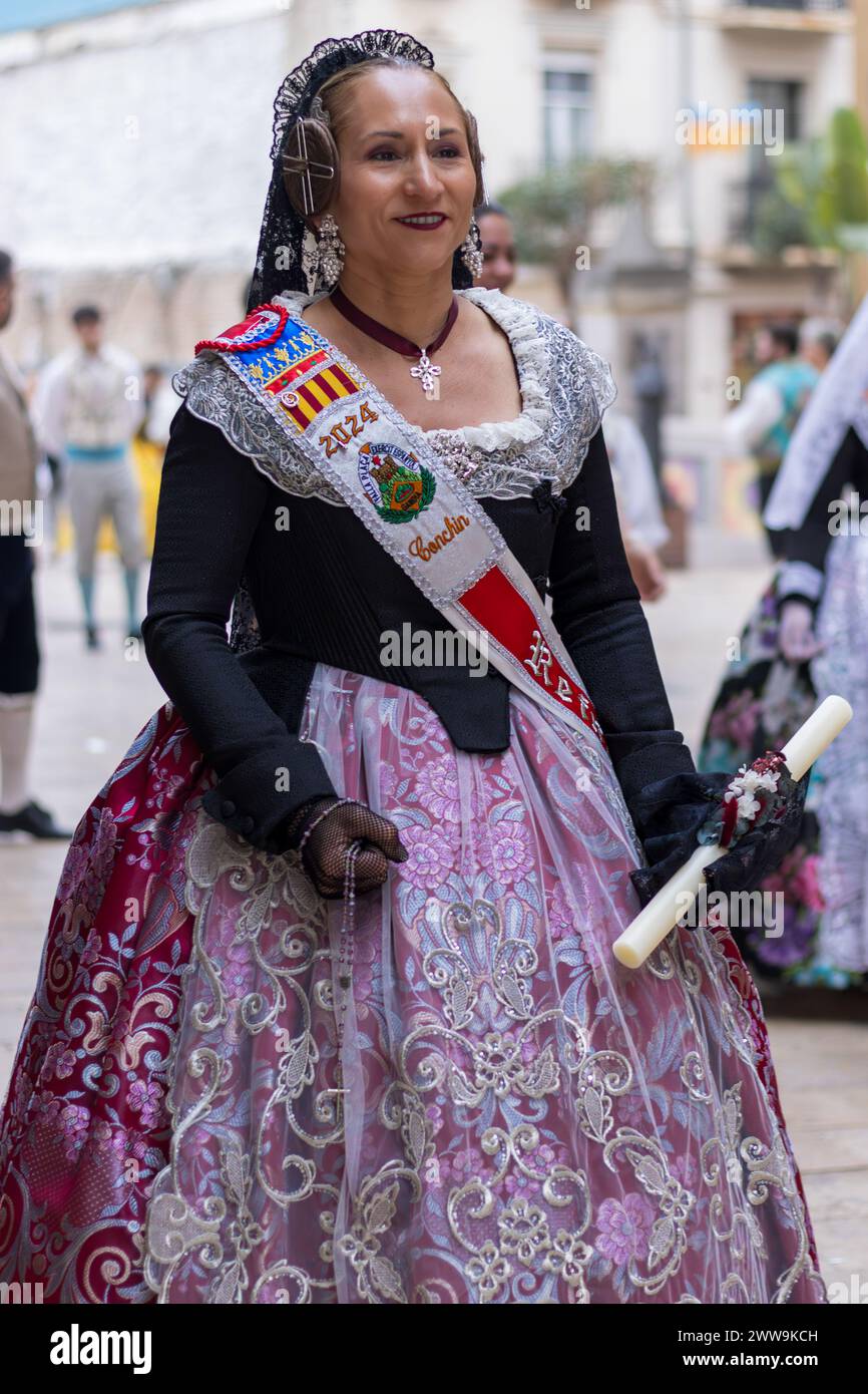 Eine Frau schmückt das Fallas-Festival mit ihrem traditionellen valencianischen Kleid, einem Wandteppich der Geschichte in jedem Stich. Beleuchtet von Kerzenlicht, ihre Kleidung Stockfoto