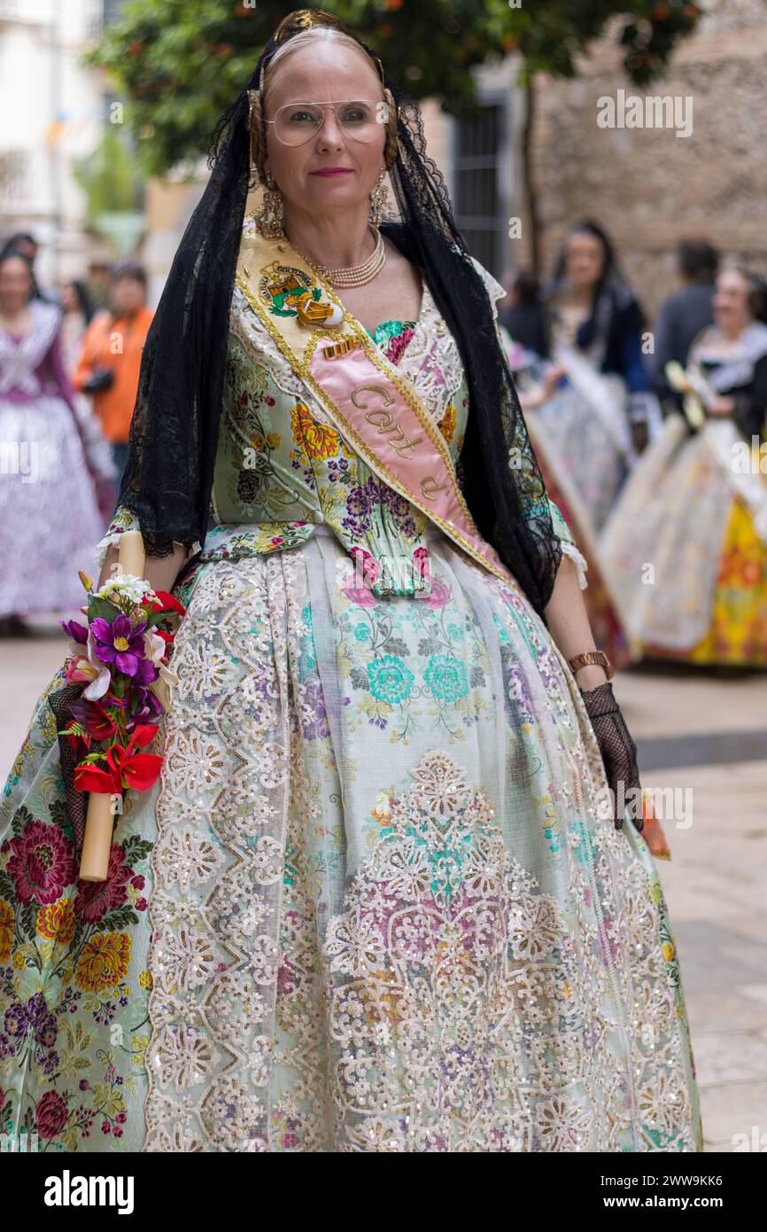 Valencian Grace in festlicher Aufstellung, eine Damenbekleidung im Fallas in Gandia erzählt eine lebendige Geschichte. Ihr Kleid, ein Meisterwerk der Tradition und Farbe, Paraden Stockfoto