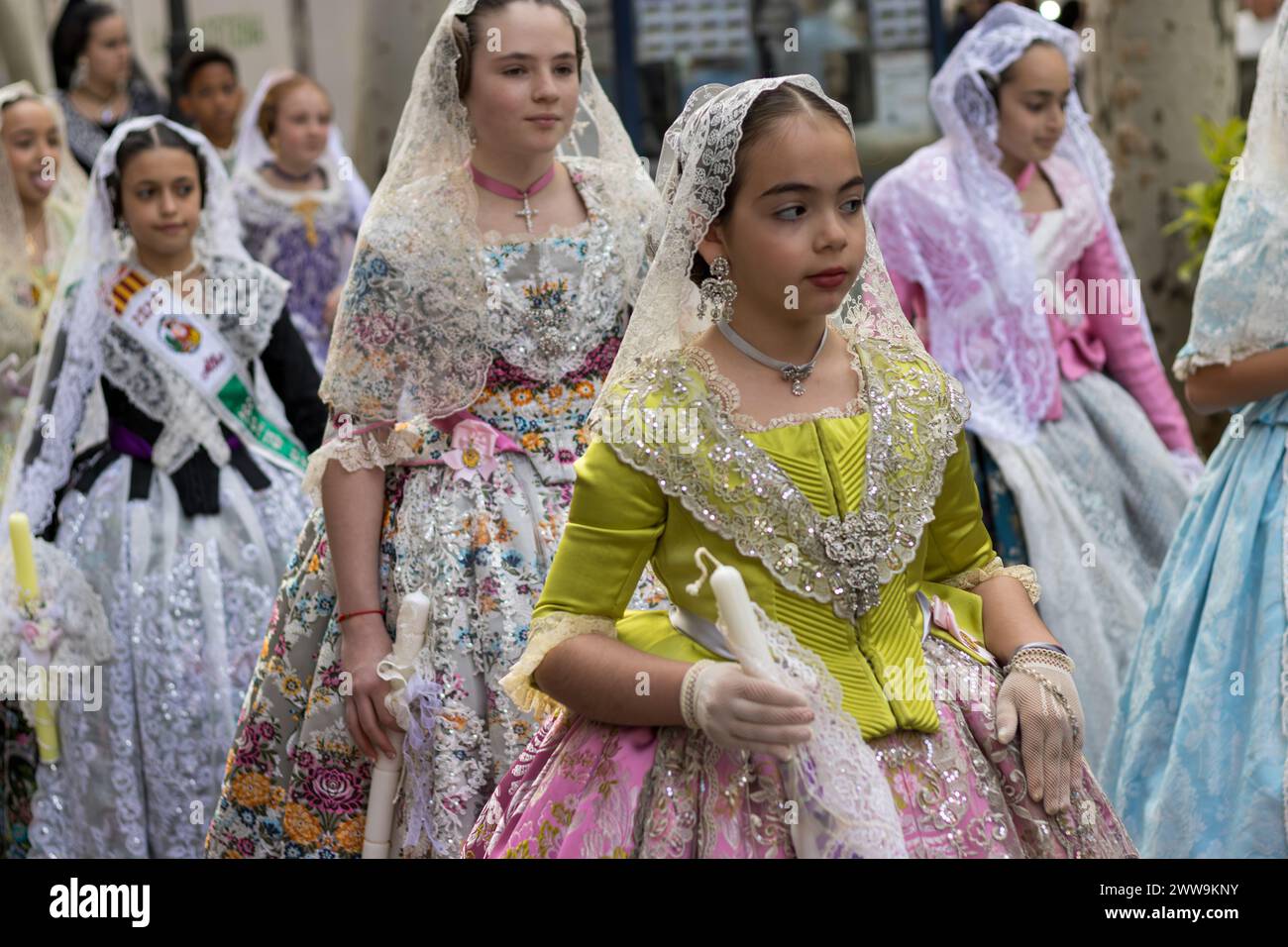 Jugendliche Eleganz im Fallas; Junge Falleras in lebendigen Kleidern zelebrieren Gandias Traditionen, ihre Kostüme sind ein Kaleidoskop der Freude des Festivals. Stockfoto