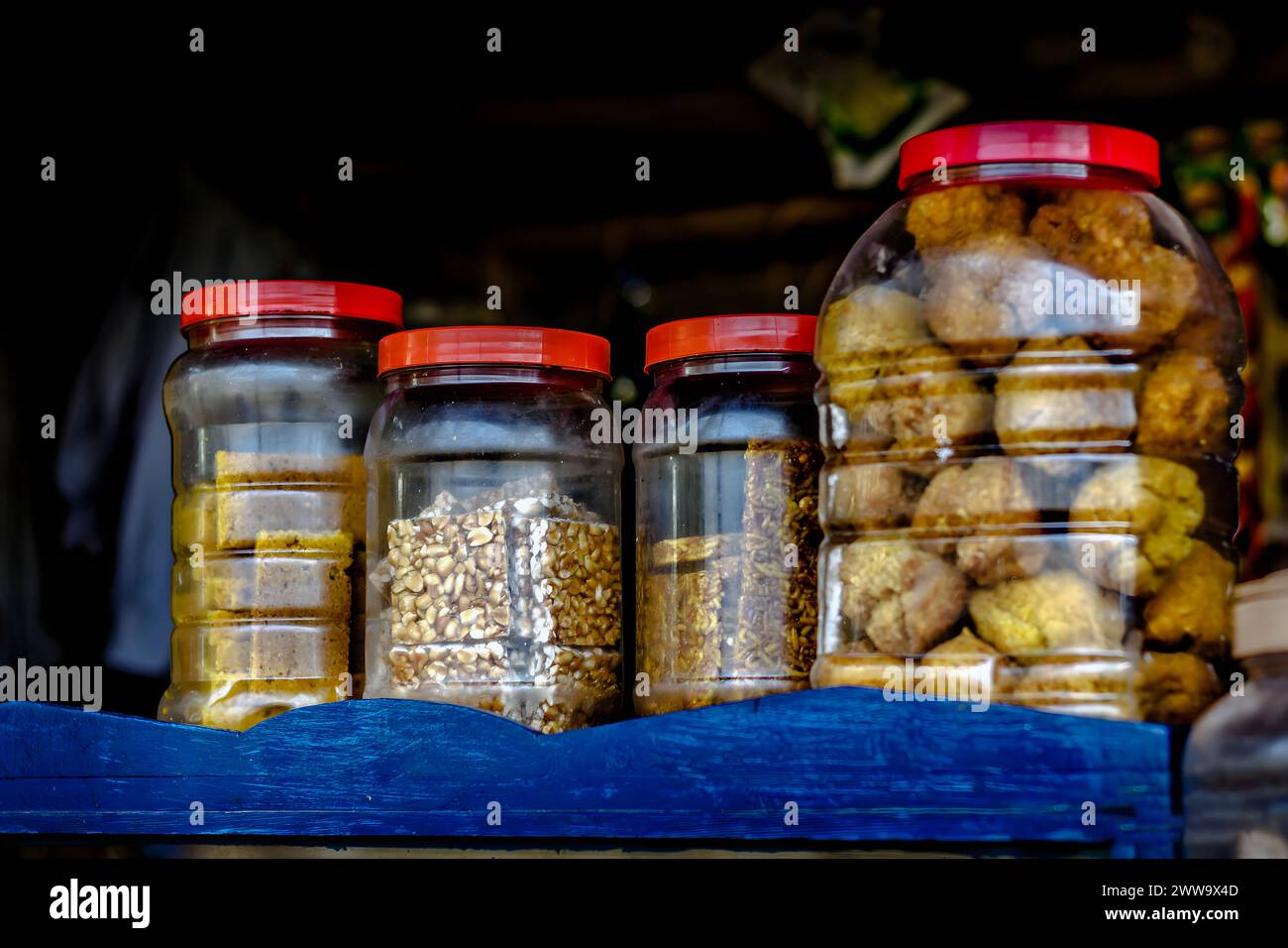 Ein traditionelles Lebensmittelgeschäft in einem indischen Dorf, das Kuchen und Süßigkeiten verkauft. Stockfoto