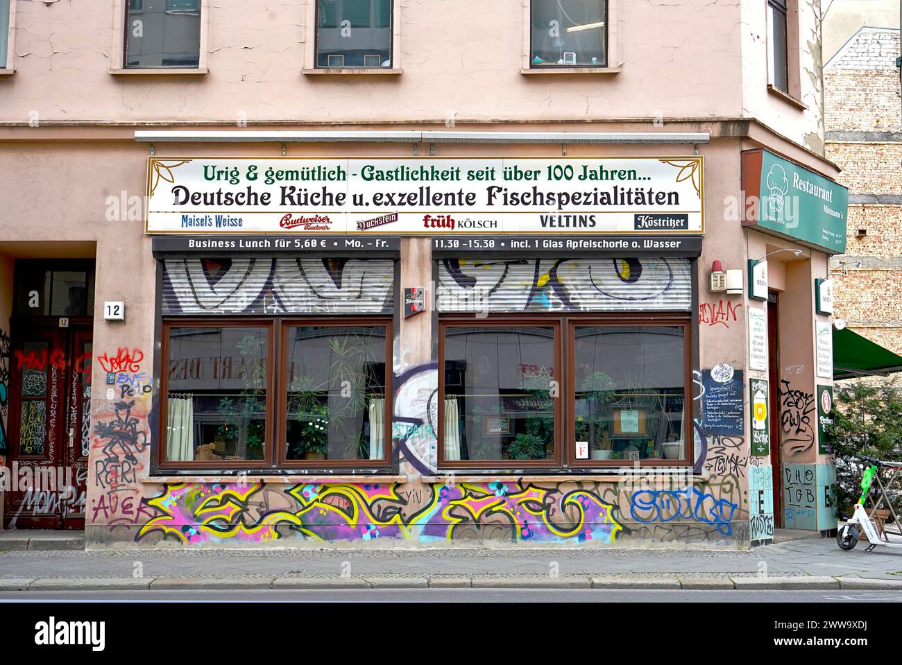 Ein Restaurant in der Berliner Innenstadt in einem alten Gebäude mit großen Fenstern und Graffiti mit 100 Jahren Gastfreundschaft, Berlin, Deutschland Stockfoto