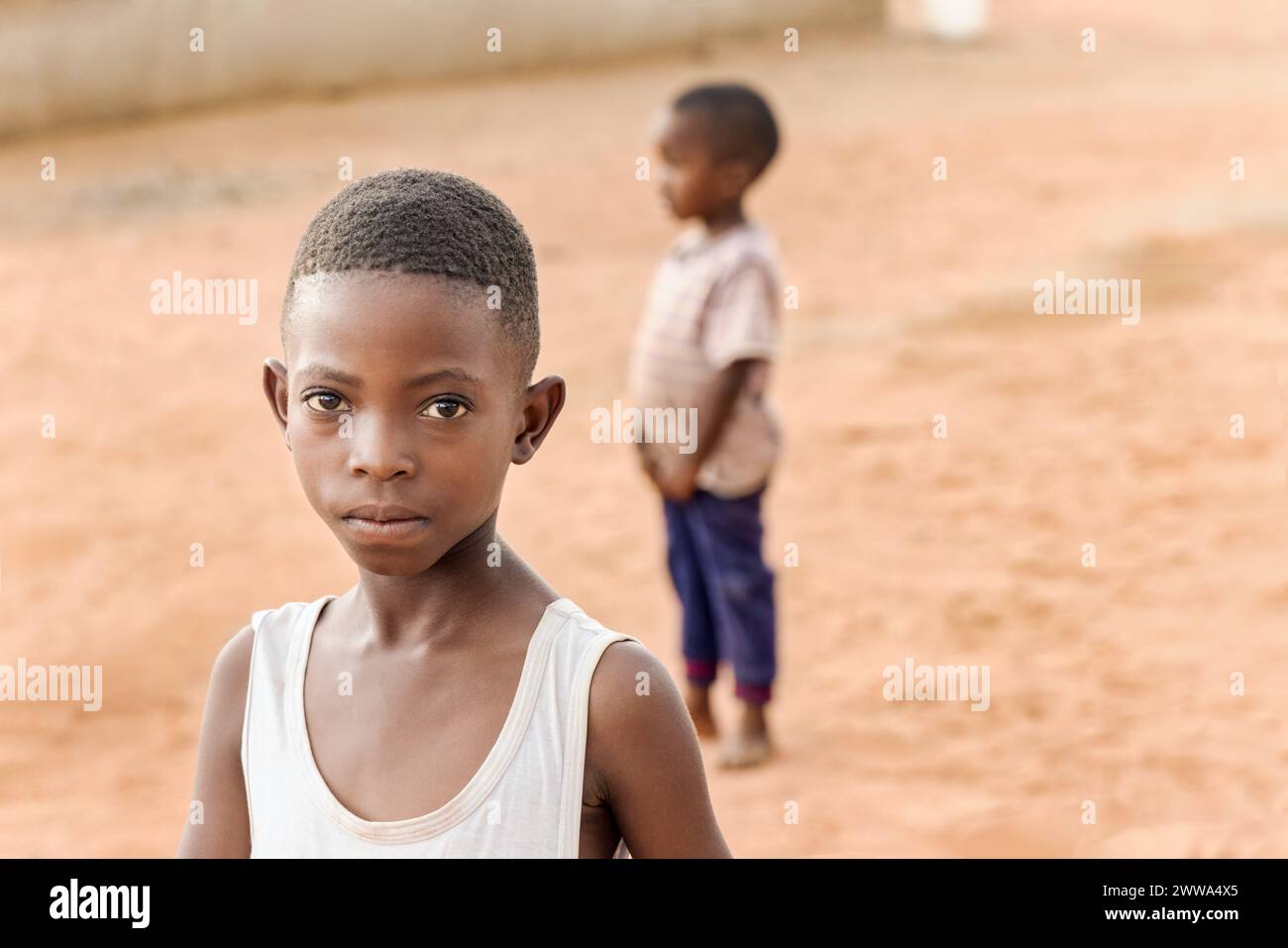 afrikanisches Dorfleben, kleines Mädchen und ein Freund spielen im Hof, am späten Nachmittag Stockfoto