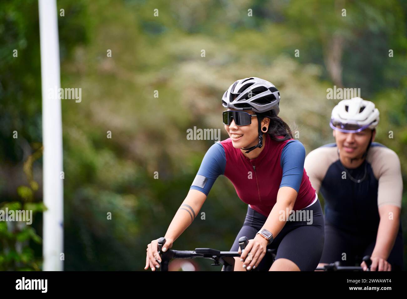 Junge asiatische Radfahrer, die auf der Landstraße Fahrrad fahren Stockfoto