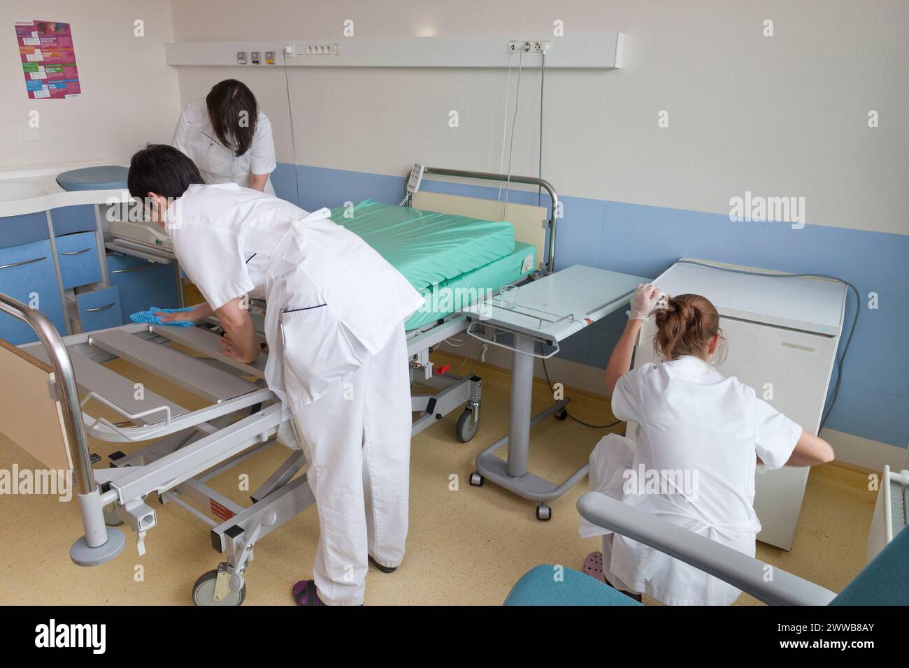 Kinderbetreuer, die ein Zimmer reinigen, nachdem ein Patient die Windelsuite verlassen hat. Stockfoto