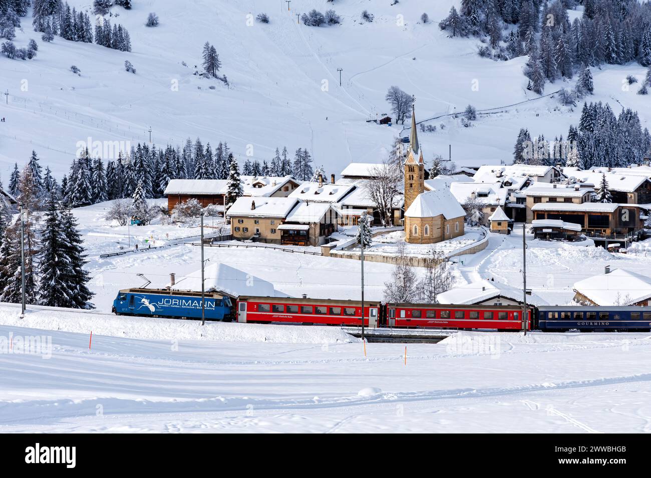 Berguen, Schweiz - 10. Januar 2024: Personenzug der Rhätischen Eisenbahn auf der Albula-Strecke in den Schweizer Alpen in Berguen, Schweiz. Stockfoto