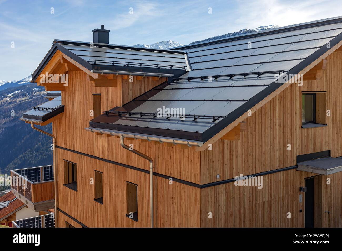 Neues Holzhaus mit Sonnendach in den Alpen Stockfoto