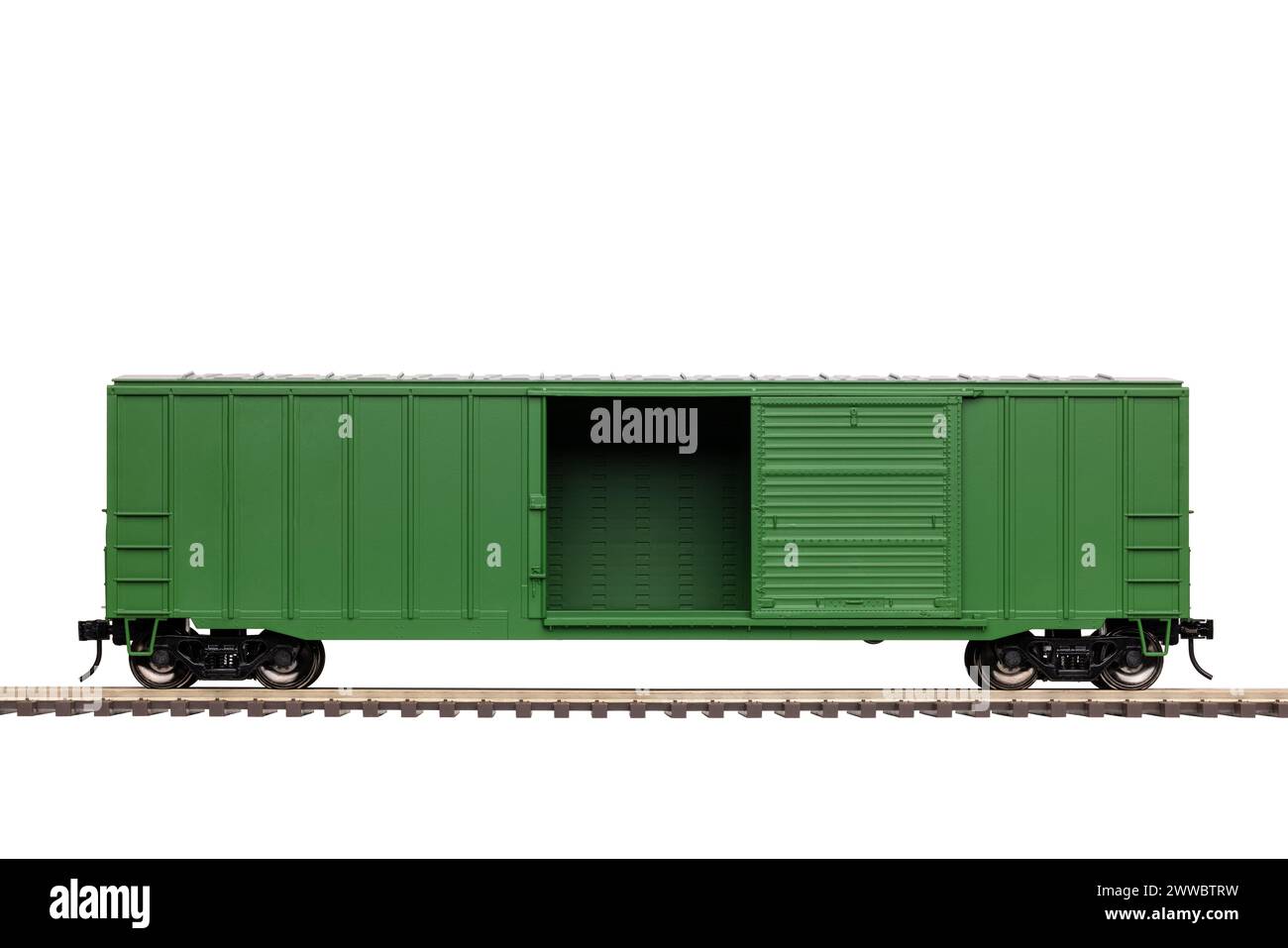 Ein grüner Eisenbahnkastenwagen mit offener Tür auf dem Gleis. Stockfoto
