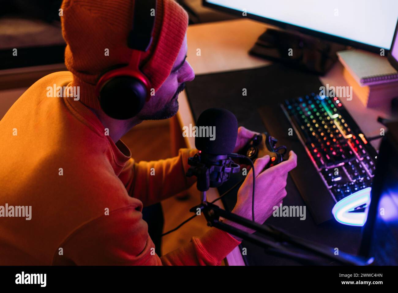 Gaming-Influencer mit kabellosen Kopfhörern und Videospielen zu Hause Stockfoto