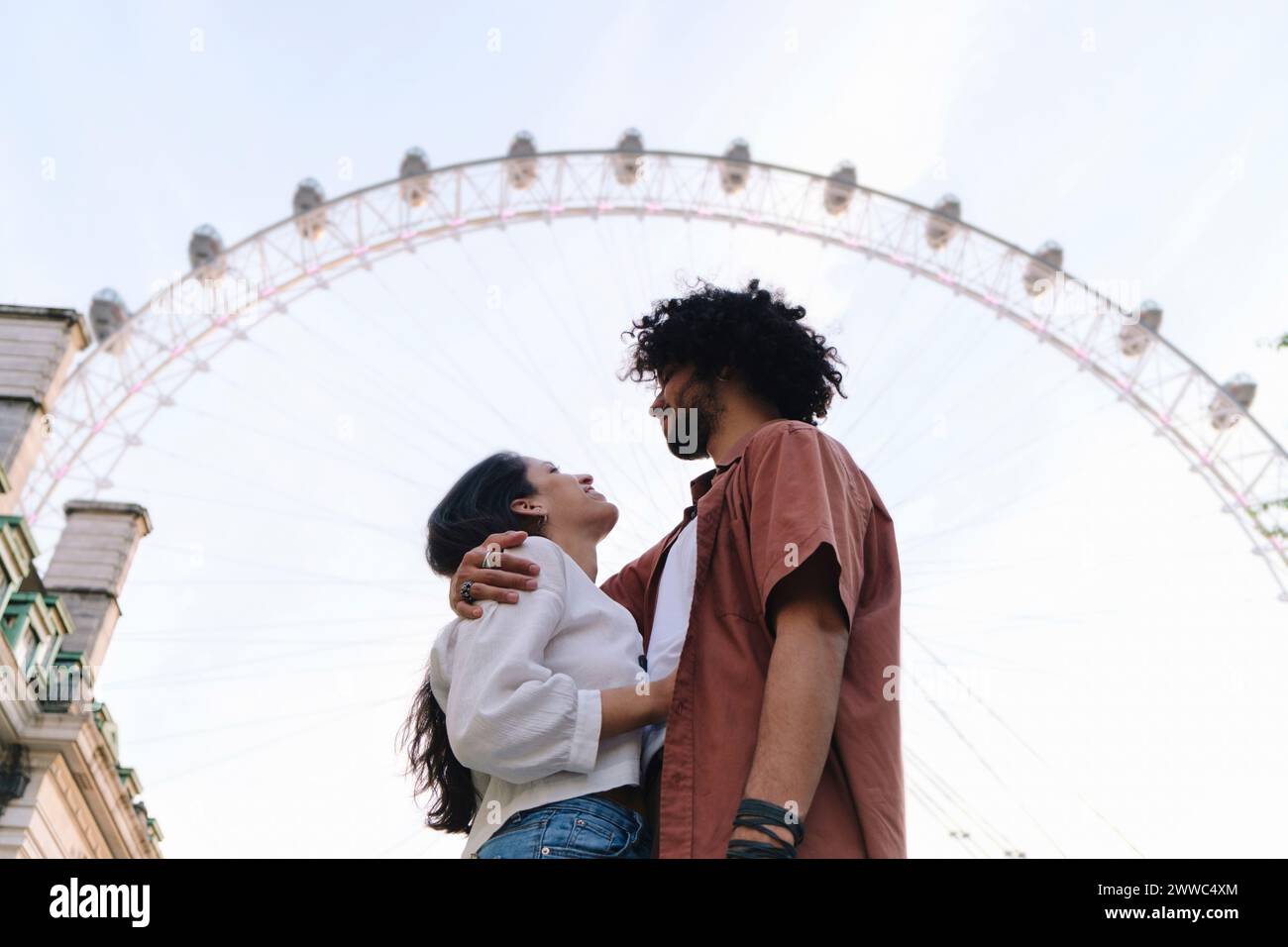 Ein junges Paar, das vor dem Riesenrad in London steht Stockfoto