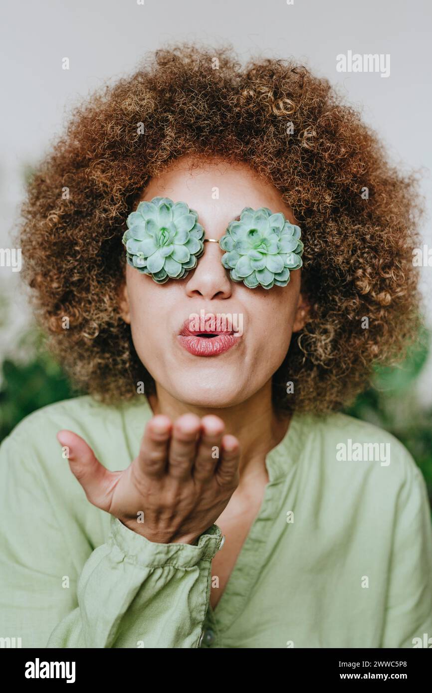 Eine Frau trägt eine echeveria-Blumenbrille und einen Kuss Stockfoto