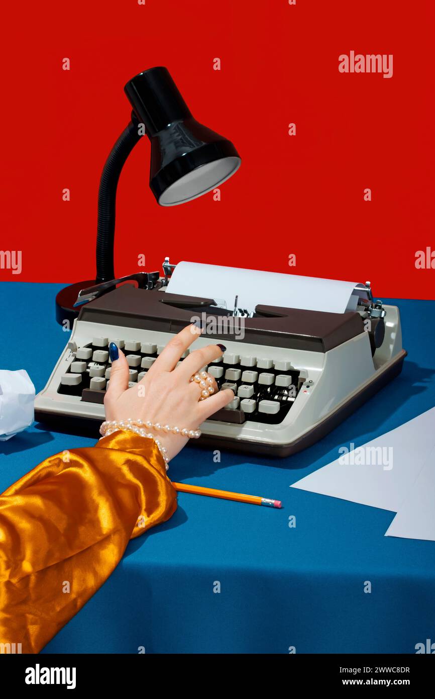 Hand des Schreibers, der auf der Schreibmaschine am Schreibtisch schreibt Stockfoto